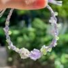 Hand woven bracelet with purple fluorite crystal and fairy like flowers, playful and sweet bracelet