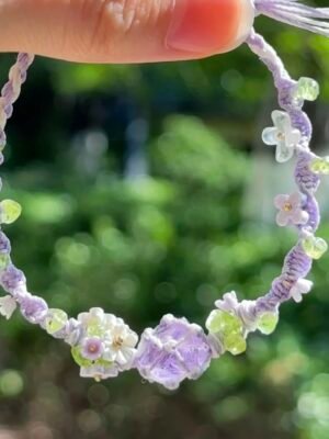 Hand woven bracelet with purple fluorite crystal and fairy like flowers, playful and sweet bracelet