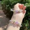 Hand woven bracelet with purple fluorite crystal and fairy like flowers, playful and sweet bracelet