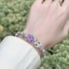 Hand woven bracelet with purple fluorite crystal and fairy like flowers, playful and sweet bracelet