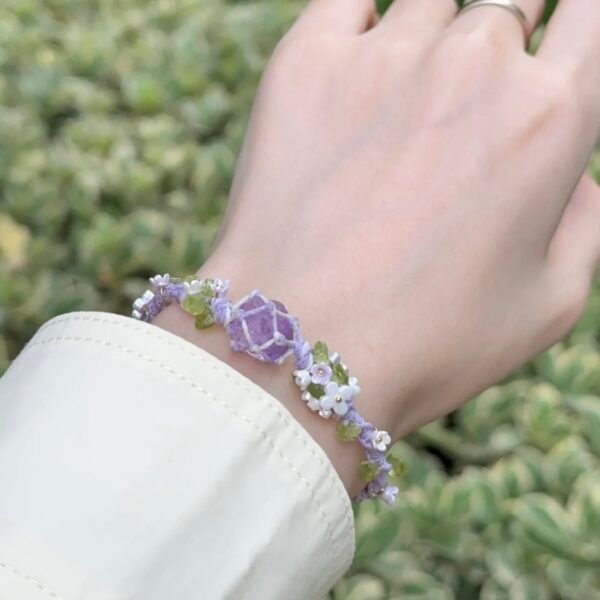 Hand woven bracelet with purple fluorite crystal and fairy like flowers, playful and sweet bracelet
